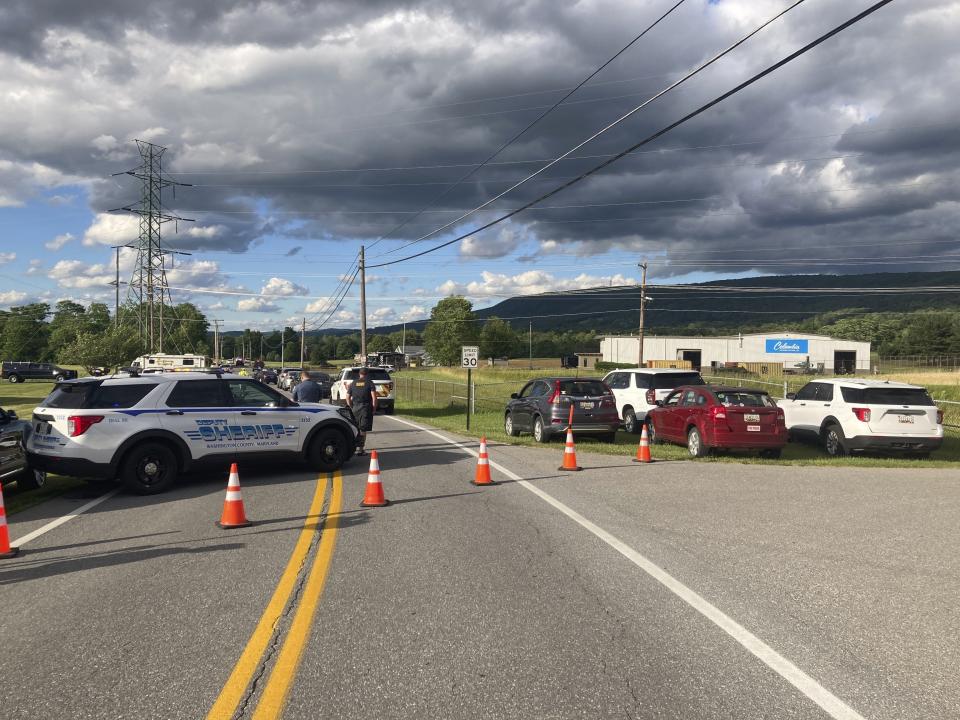 Law enforcement vehicles block the road at the scene of a shooting at a Maryland business near Smithsburg, Md., on Thursday June, 9 2022. A man opened fire at a manufacturing business in rural western Maryland on Thursday, killing multiple people before the suspect and a state trooper were wounded in a shootout, authorities said.(AP Photo/Michael Kunzelman)
