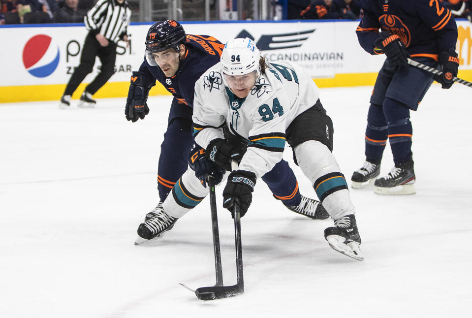 San Jose Sharks' Alexander Barabanov (94) and Edmonton Oilers' Evan Bouchard (75) battle for the puck during first-period NHL hockey game action in Edmonton, Alberts, Thursday, April 28, 2022. (Jason Franson/The Canadian Press via AP)