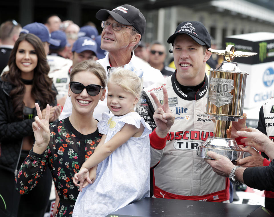 NASCAR Cup Series driver Brad Keselowski (2) celebrates with his wife Paige and daughter Scarlett after winning the NASCAR Brickyard 400 auto race at Indianapolis Motor Speedway, in Indianapolis Monday, Sept. 10, 2018. (AP Photo/Michael Conroy)