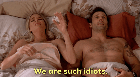 A couple laying in bed with the woman saying, "We are such idiots."