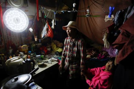 Migrant worker Wang Qin and her 10-year-old granddaughter Feng Aobin sit in their one-room home at the outskirts of Beijing, China October 1, 2017. REUTERS/Thomas Peter