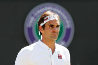 Tennis - Wimbledon - All England Lawn Tennis and Croquet Club, London, Britain - July 11, 2018. Switzerland's Roger Federer is framed by the tournament logo during his quarter final match against South Africa's Kevin Anderson. REUTERS/Andrew Boyers