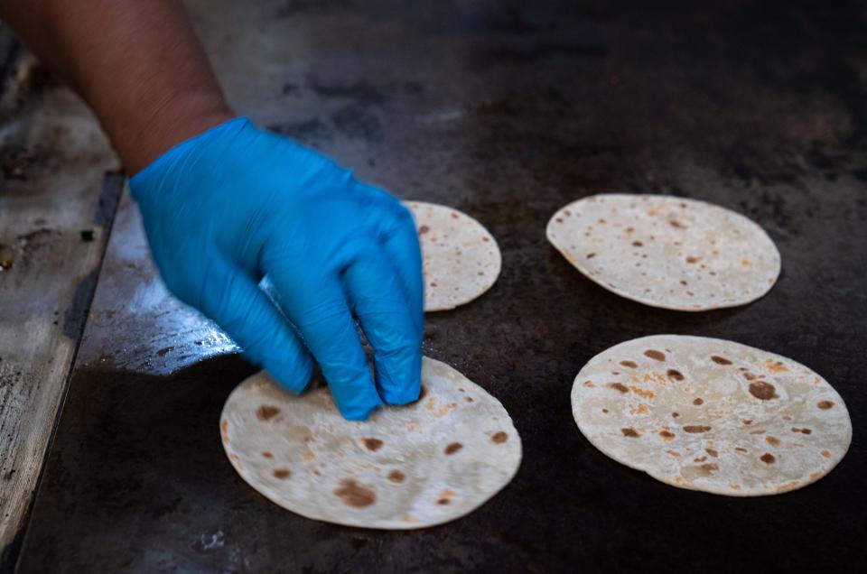 Jose Martinez (manager) warms tortillas on May 9, 2023, in the kitchen at Tacos Calafia in Phoenix.