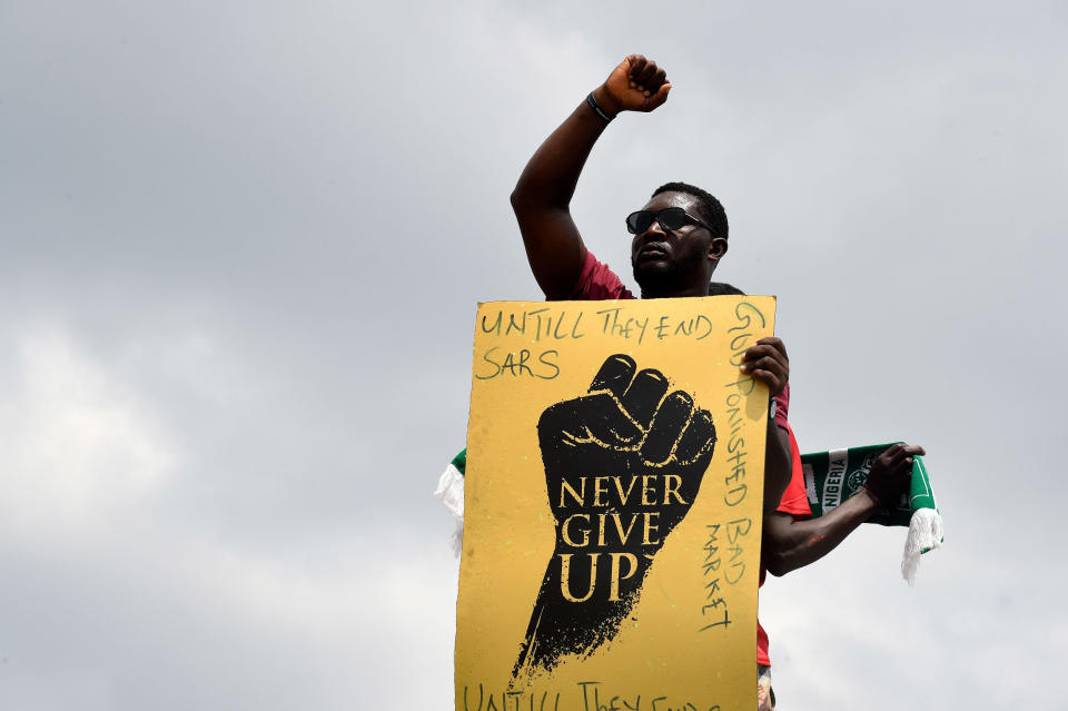 Image: A protester raises his fist and holds a placard during a demonstration to protest against police brutality at Magboro, Ogun State in southwest Nigeria (Pius Utomi Ekpei / AFP - Getty Images)