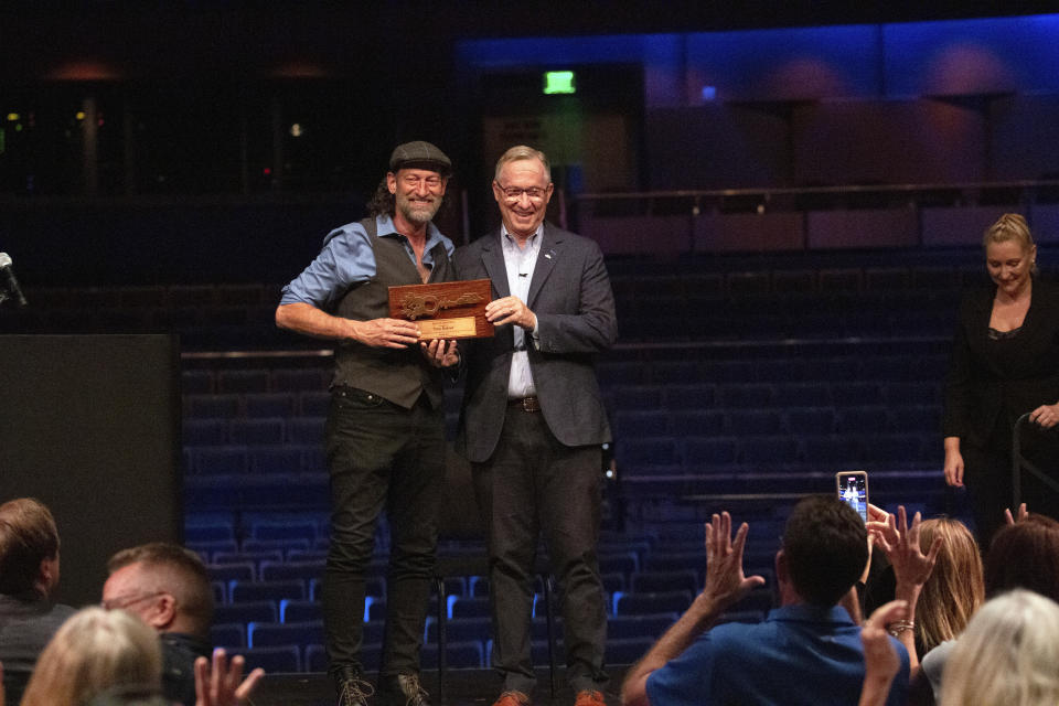 In this image provided by the City of Mesa, actor Troy Kotsur, left, receives the key to the city from Mesa Mayor John Giles, on Thursday, Aug. 11, 2022 in Mesa, Ariz. Kotsur, who made history as the first deaf man to win an Academy Award, has been honored with a key to his Arizona hometown. (Delia Johnson/City of Mesa via The AP)