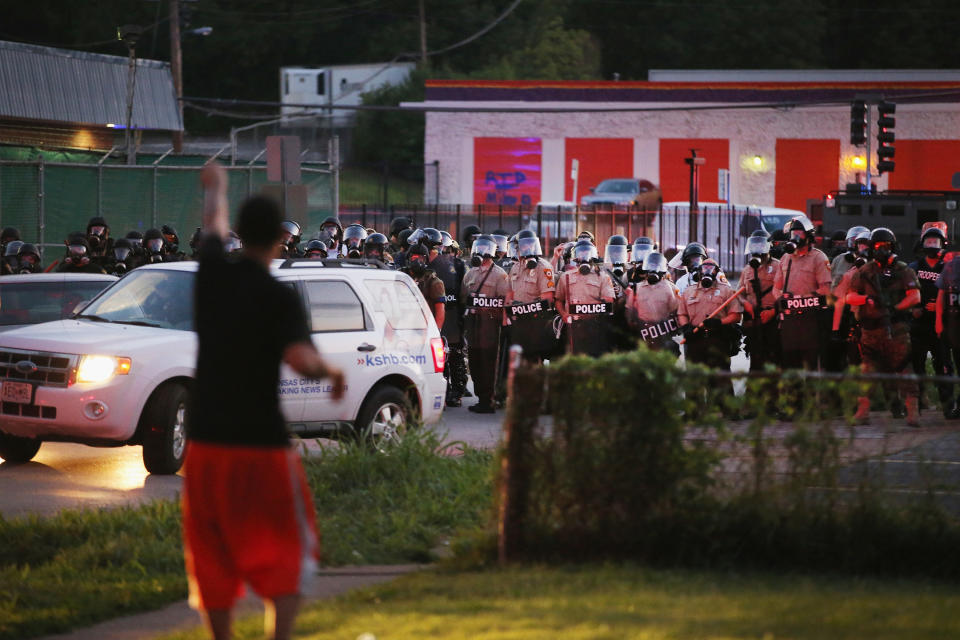 FERGUSON, MO - AUGUST 11:  Police force protestors from the business district into nearby neighborhoods on August 11, 2014 in Ferguson, Missouri. Police responded with tear gas and rubber bullets as residents and their supporters protested the shooting by police of an unarmed black teenager named Michael Brown who was killed Saturday in this suburban St. Louis community. Yesterday 32 arrests were made after protests turned into rioting and looting in Ferguson.  (Photo by Scott Olson/Getty Images)