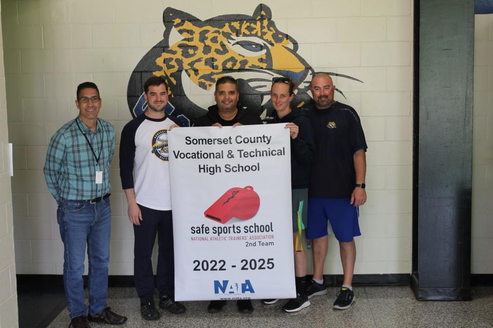 (Left to right) SCVTHS Principal Hector Montes, SCVTHS Athletic Trainer Tim Mancuso, SCVTHS Supervisor of Athletics Jaime Morales, SCVTHS Physical Education Instructor Maura Gillooly and SCVTHS Physical Education Instructor Jack O’Neill pose for a photo with the Safe Sports School banner.
