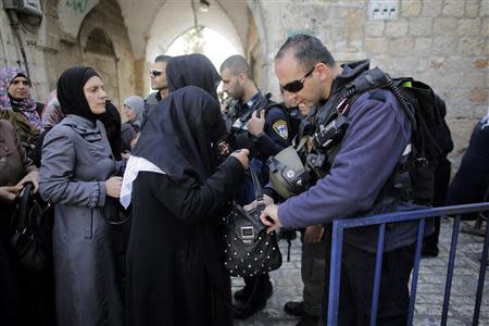 An Israeli policeman checks the bag of a Palestinian woman before she enters the compound which houses al-Aqsa mosque and is known to Muslims as Noble Sanctuary and to Jews as Temple Mount in Jerusalem's Old City April 16, 2014. REUTERS/Ammar Awad