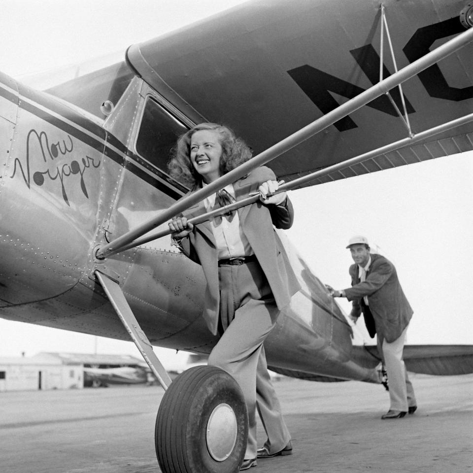 Bette Davis and her third husband, William Grant Sherry, pushing the airplane "Now Voyager," circa 1947.&nbsp;