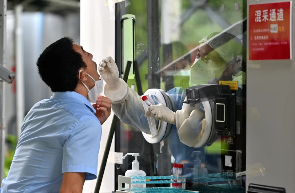 A medical worker takes a swab sample from a man for nucleic acid test in Sanya, south China&#39;s Hainan Province, Aug. 26, 2022. (Photo by Guo Cheng/Xinhua via Getty Images)