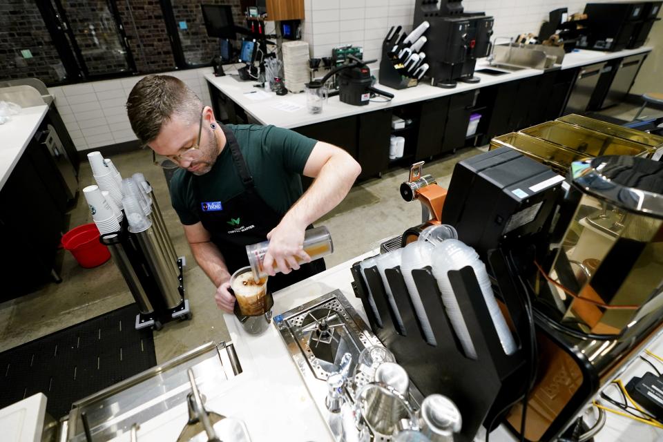 Tryer Lab partner Antonio Retano pours a drink during a reusable personal cup test at the Tryer Center at Starbucks headquarters, Wednesday, June 28, 2023, in Seattle. The company's goals is to cut waste, water use and carbon emissions in half by 2030. (AP Photo/Lindsey Wasson)