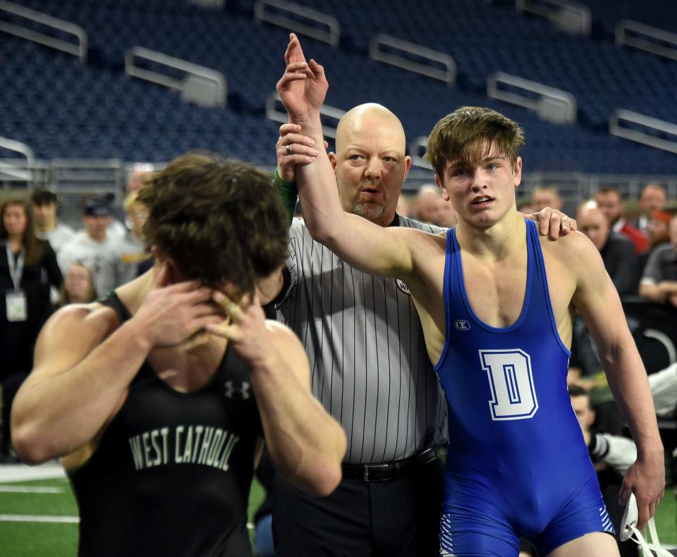 Kole Katschor of Dundee has his arm raised after he beat Cole Karasinski of West Catholic in the 150 pound match 5-4 in overtime in the MHSAA Division 3 state finals at Ford Field Saturday, March 4, 2023.
