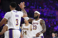 Los Angeles Lakers forward LeBron James congratulates forward Anthony Davis during a timeout in the first half of the team's preseason NBA basketball game against the Golden State Warriors on Wednesday, Oct. 16, 2019, in Los Angeles. (AP Photo/Mark J. Terrill)