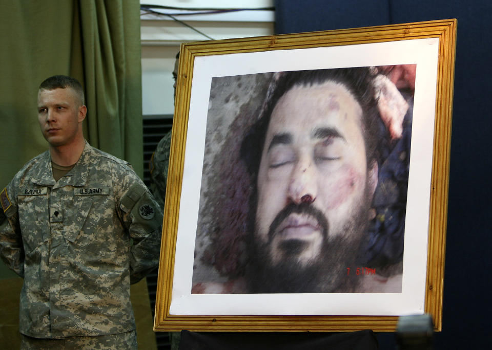 A U.S. soldier stands next to the picture of the dead al Qaeda leader in Iraq, Abu Musab al-Zarqawi, during a news conference at the fortified Green Zone in Baghdad June 8, 2006. REUTERS/Ceerwan Aziz