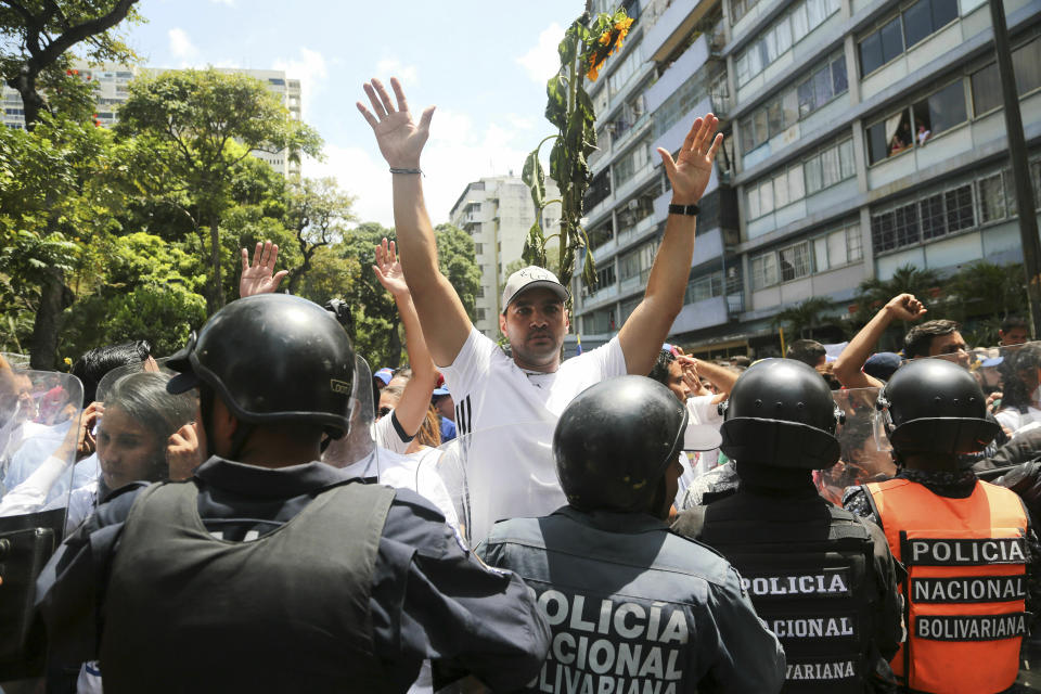 Demonstrators confront a cordon of Venezuelan National Police officer who temporarily block members of the opposition from reaching a rally against the government of President Nicolas Maduro in Caracas, Venezuela, Saturday, March 9, 2019. (AP Photo/Fernando Llano)