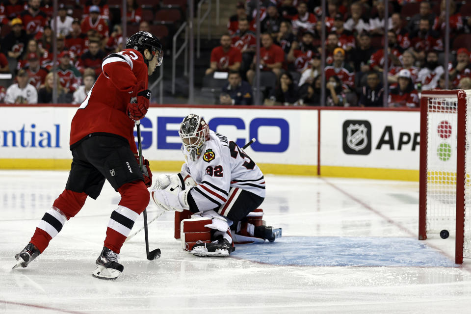 New Jersey Devils center Nico Hischier (13) watches as a goal scored by teammate Dougie Hamilton (not shown) gets past Chicago Blackhawks goaltender Kevin Lankinen (32) during the first period of an NHL hockey game Friday, Oct. 15, 2021, in Newark, N.J. (AP Photo/Adam Hunger)