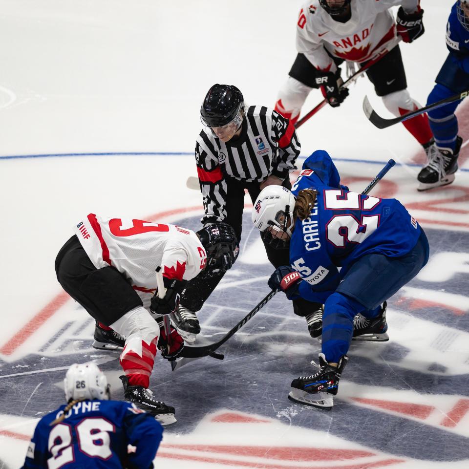 Canada's Marie-Philip Poulin and Team USA's Alex Carpenter (from left) battle during the opening faceoff at the Adirondack Bank Center Monday.