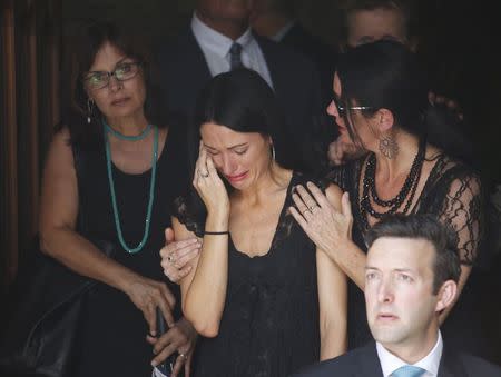 Mourners react as they leave the funeral of Sydney cafe siege victim, cafe manager Tori Johnson at St Stephens Uniting Church in Sydney, December 23, 2014. REUTERS/Jason Reed