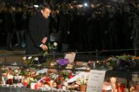 French President Emmanuel Macron lays a white rose at a monument near the Christmas market in Strasbourg, where four people where killed by a gunman this week