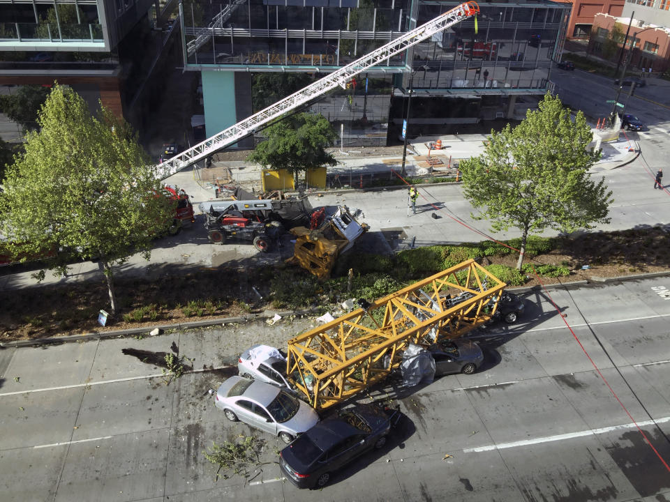 Fire and police crew members work to clear the scene where a construction crane fell from a building on Google's new Seattle campus crashing down onto one of the city's busiest streets and killing multiple people on Saturday, April 27, 2019. (AP Photo/Frank Kuin)