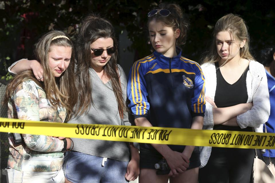 Visitors react as they visit a memorial near the scene of a 4th-story apartment building balcony collapse in Berkeley