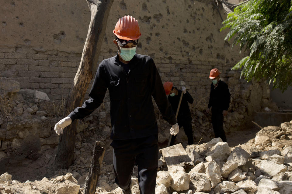 In this Saturday, Sept. 7, 2019, photo, workers dig for bodies at the site of a mass grave in Raqqa, Syria. First responders said they have pulled nearly 20 bodies out of the latest mass grave uncovered in Raqqa, the Syrian city that was the de facto capital of the Islamic State group. It is the 16th mass grave in the city, and officials are struggling with a lack of resources needed to document and one day identify the thousands of dead who have been dug out. (AP Photo/Maya Alleruzzo)
