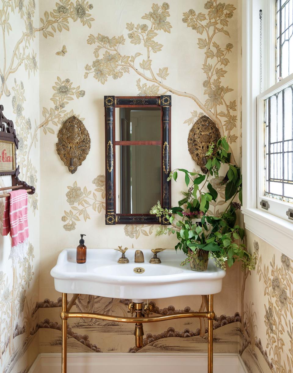A sweet bathroom area blooms anew thanks to a leafy wallpaper.
