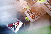 In this Aug. 8, 2019 photo, protesters with "No Abe!" signs stand during a rally outside Japanese Prime Minister Shinzo Abe's residence in Tokyo. South Korea and Japan have locked themselves in a highly-public dispute over history and trade that in a span of weeks saw their relations sink to a low unseen in decades. (AP Photo/Eugene Hoshiko)