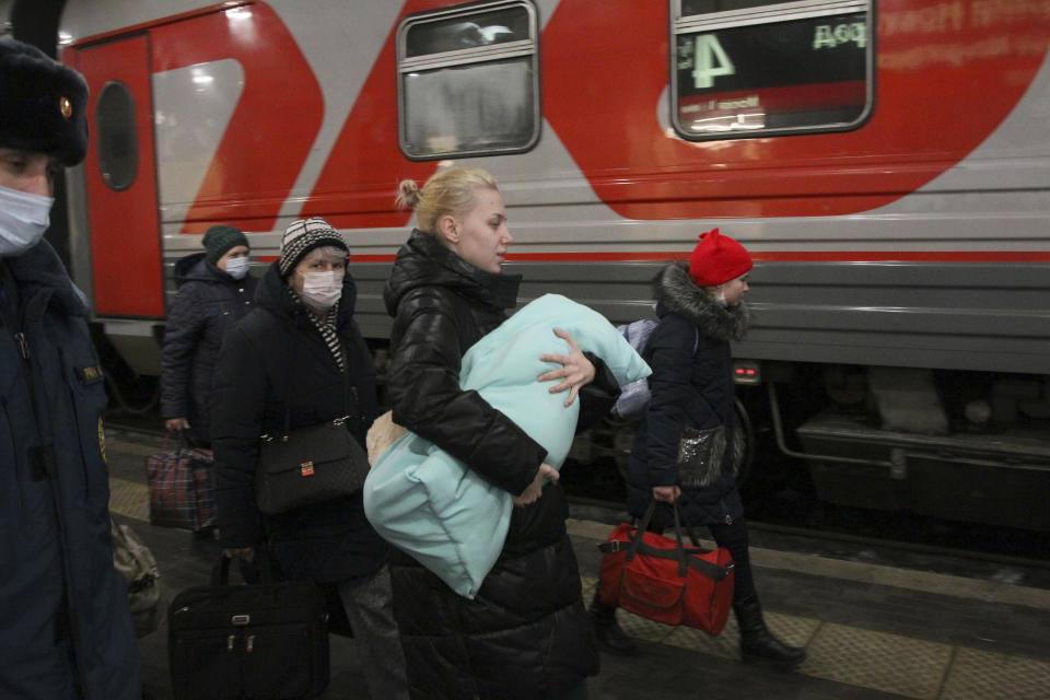 People from the Donetsk region, the territory controlled by pro-Russia separatist governments in eastern Ukraine, leave a train to be taken to temporary residences in Nizhny Novgorod region, at the railway station in Nizhny Novgorod, Russia, Tuesday, Feb. 22, 2022. A long-feared Russian invasion of Ukraine appears to be imminent, if not already underway, with Russian President Vladimir Putin ordering forces into separatist regions of eastern Ukraine. (AP Photo/Roman Yarovitcyn)