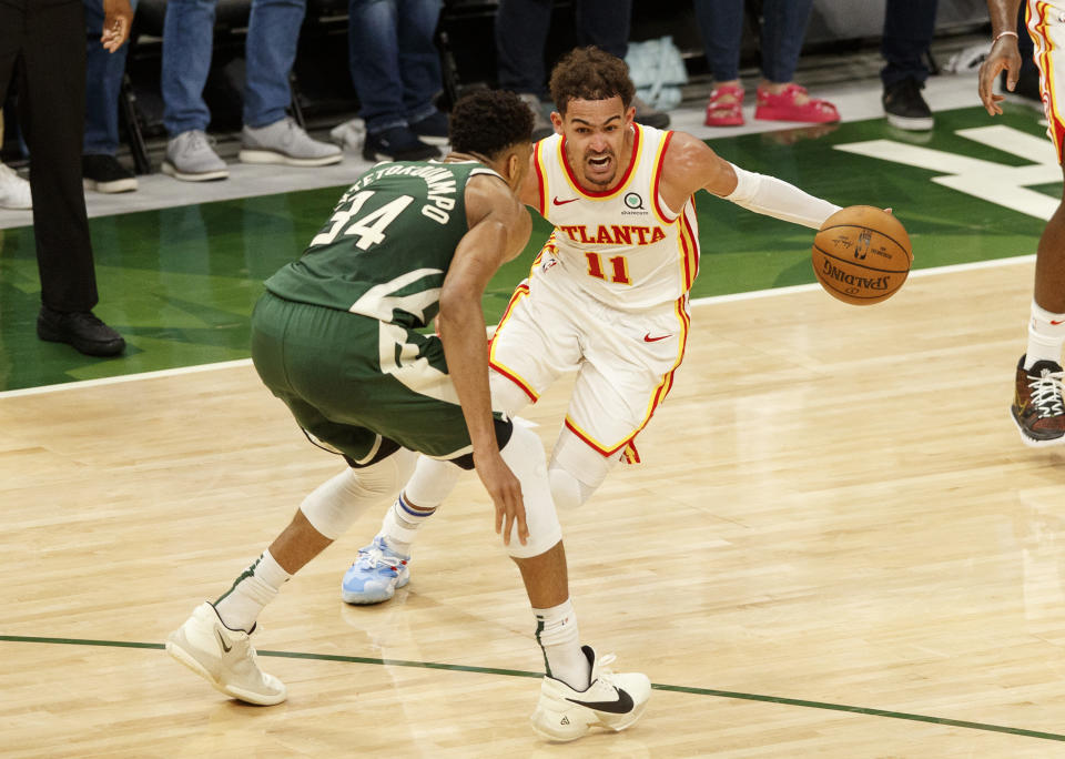 Trae Young drives for the basket against Giannis Antetokounmpo.