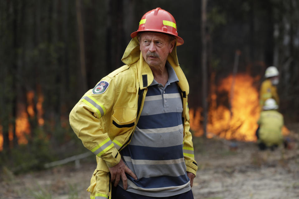 Doug Schutz, the Tomerong Rural Fire Service Captain, oversees a controlled burn near Tomerong, Australia, Wednesday, Jan. 8, 2020, set in an effort to contain a larger fire nearby. Schutz began volunteering with the Rural Fire Service in New South Wales some 53 years ago, at the age of 13. That was back in the days when the fire truck was a Land Rover that towed a trailer with a water pump on top. Schutz is part of an army of 72,000 people from across the state who make up the world's largest volunteer fire service. (AP Photo/Rick Rycroft)