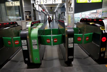 A passenger waits for the resumption of train service in a snarl caused by Typhoon Faxai at Komagome station in Tokyo,