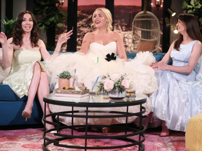 Busy Philipps sits on a couch wearing her wedding dress on an episode of &quot;Busy Tonight.&quot;