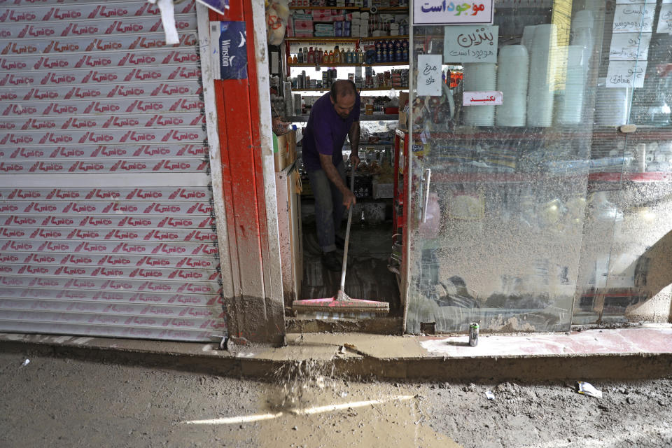A man cleans his shop after flash flooding at Imamzadeh Davood village in the northwestern part of Tehran, Iran, Thursday, July 28, 2022. Heavy rains in the early hours of Thursday caused flash floods and then landslides and caused damage to Imamzadeh Davood, a religious shrine in the city. (AP Photo/Vahid Salemi)