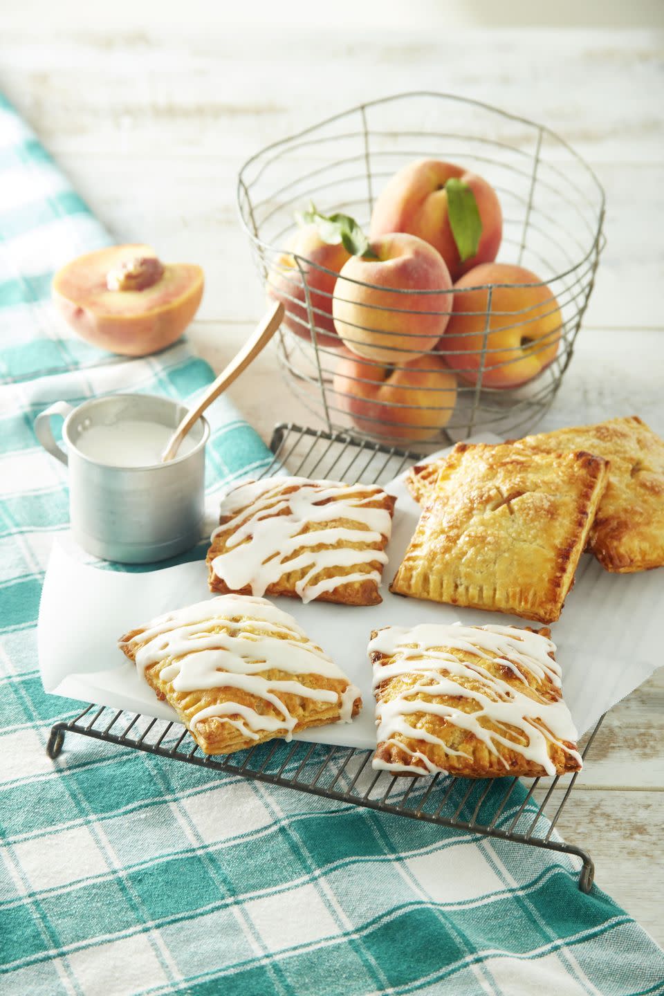spiced peach hand pies drizzled with glaze and arranged on a wire rack