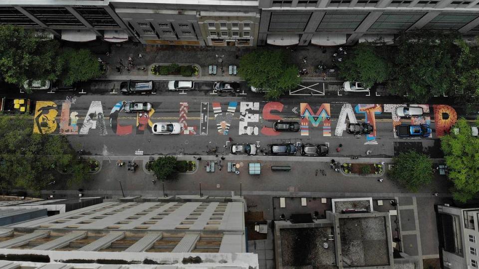 Traffic flows over the Black Lives Matter mural along North Tryon Street on Wednesday, June 10, 2020, days after the artwork was painted.