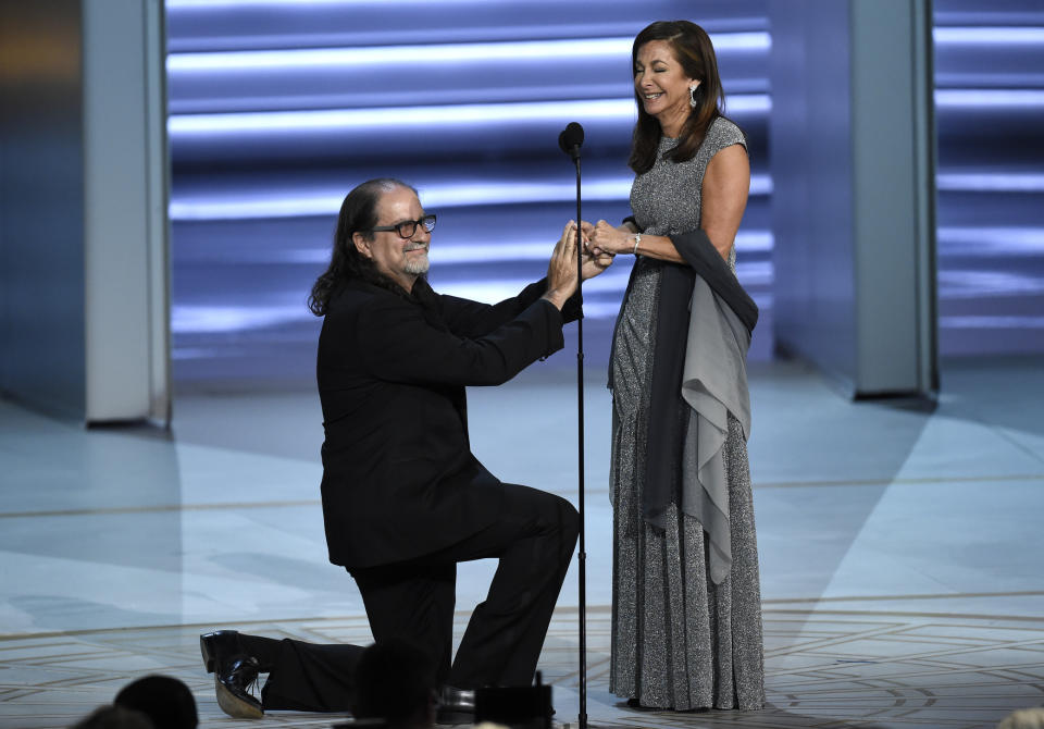 FILE - In this Sept. 17, 2018 file photo, Glenn Weiss, winner of the Emmy for outstanding directing for a variety special for "The Oscars," left, surprised the audience, and his girlfriend Jan Svendsen by proposing at the 70th Primetime Emmy Awards in Los Angeles. (Photo by Chris Pizzello/Invision/AP, File)