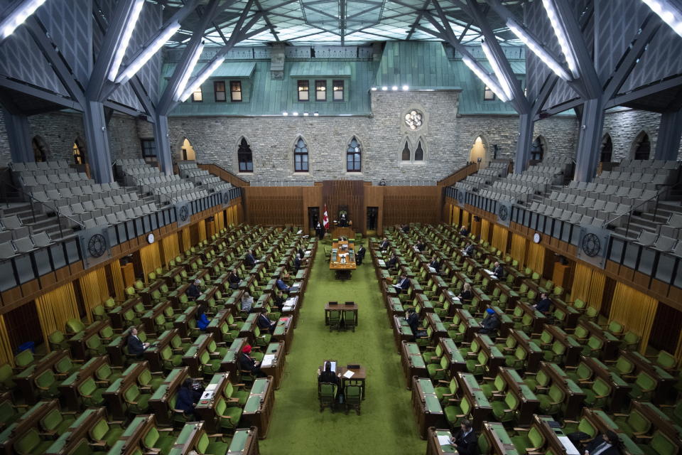 Members of Parliament, attending in limited numbers and seated apart to practice social distancing, wait for proceedings to begin in the House of Commons on Parliament Hill in Ottawa, Canada as Parliament was recalled for the consideration of measures related to the COVID-19 coronavirus pandemic, on Saturday, April 11, 2020. (Justin Tang/The Canadian Press via AP)