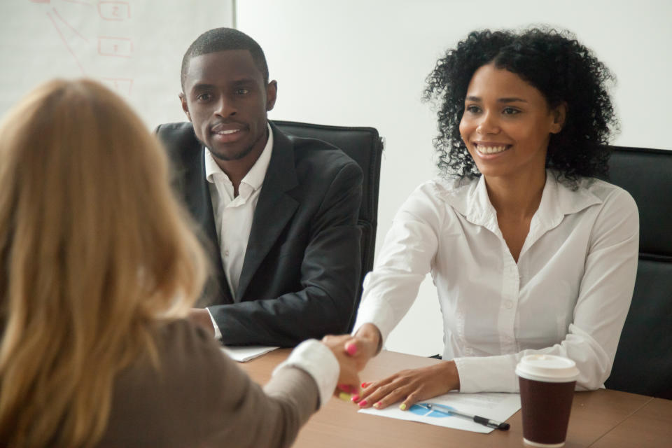 African american hr team welcoming female applicant at job interview, diverse businesswomen shaking hands at multi ethnic group meeting, handshaking and good first impression, teamwork introduction