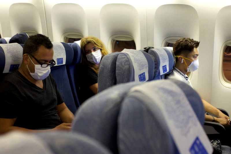 Passengers wearing masks sit on an Air China flight from Sydney to Beijing before takeoff, in Sydney