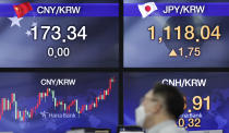 A currency trader talks near the screens showing the foreign exchange rates at the foreign exchange dealing room in Seoul, South Korea, Thursday, Sept. 3, 2020. Asian stock markets rose Thursday after Wall Street turned in its biggest daily gain since July despite uncertainty about the global outlook. (AP Photo/Lee Jin-man)