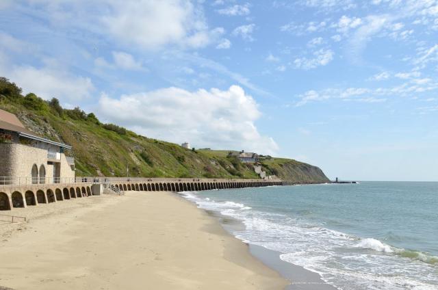 People scooter past a sign at Boscombe Beach in Dorset. A sweltering 34C  (93.2F) is expected in London and potentially some spots in East Anglia on  Friday, according to the Met Office.