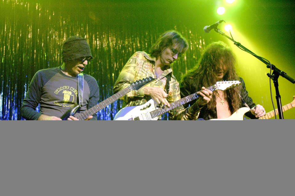 (from left) Joe Satriani, Steve Vai and Yngwie Malmsteen perform onstage in Chicago, Illinois on October 24, 2003