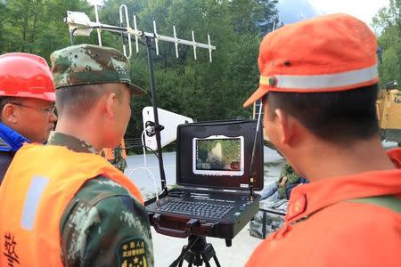 Chinese paramilitary police look at a screen as they use a drone to investigate the collapse situation after an earthquake in Jiuzhaigou county, Ngawa prefecture, Sichuan province, China August 9, 2017. REUTERS/Stringer