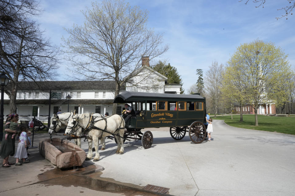 A horse drawn bus is seen on the Village Green at The Henry Ford, Friday, April 14, 2023, in Dearborn, Mich. Named after Ford Motor Co. founder and American industrialist Henry Ford, The Henry Ford sits on 250 acres and features a museum and Greenfield Village where more than 80 historic structures are displayed and maintained. The Jackson House from Selma, Ala., will join the courthouse where Abraham Lincoln first practiced law, the laboratory where Thomas Edison perfected the light bulb and the home and workshop where Orville and Wilbur Wright invented their first airplane. (AP Photo/Carlos Osorio)