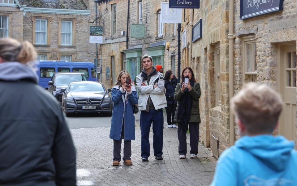 Visitors take photographs on Stow's high street