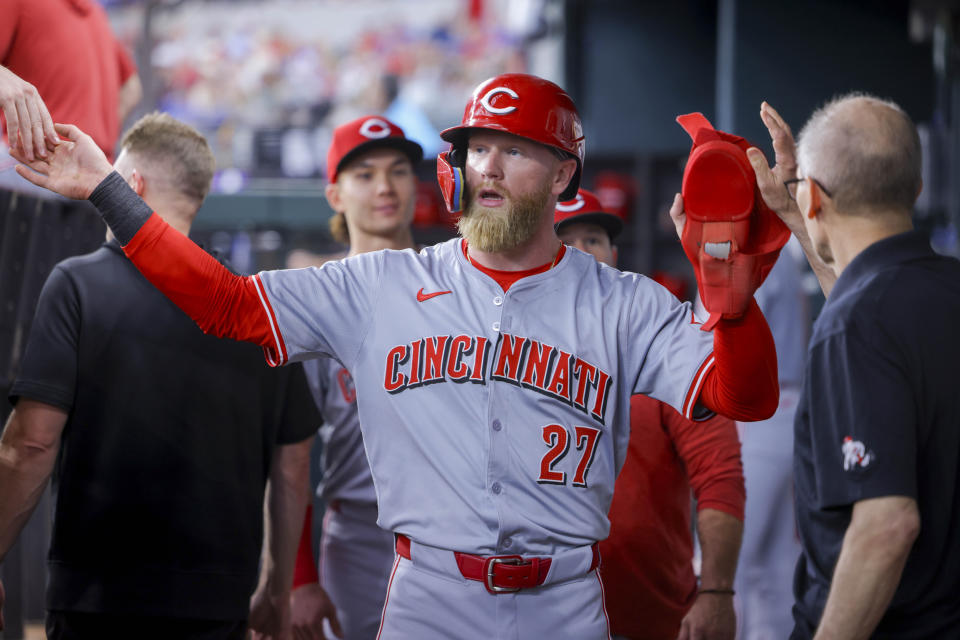 Cincinnati Reds' Jake Fraley celebrates with teammates in the dugout after scoring on a sacrifice fly from Nick Martini during the first inning of a baseball game against the Texas Rangers in Arlington, Texas, Saturday, April 27, 2024. (AP Photo/Gareth Patterson)