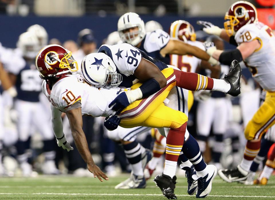 ARLINGTON, TX - NOVEMBER 22: Robert Griffin III #10 of the Washington Redskins is tackled by DeMarcus Ware #94 of the Dallas Cowboys during a Thanksgiving Day game at Cowboys Stadium on November 22, 2012 in Arlington, Texas. (Photo by Ronald Martinez/Getty Images)