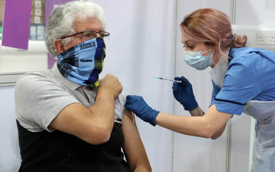 69 year old John Loch from Glasgow receives his Covid-19 vaccination from vaccinator Nicole Clark at the NHS Louisa Jordan Hospital in Glasgow. -  Andrew Milligan/PA Wire