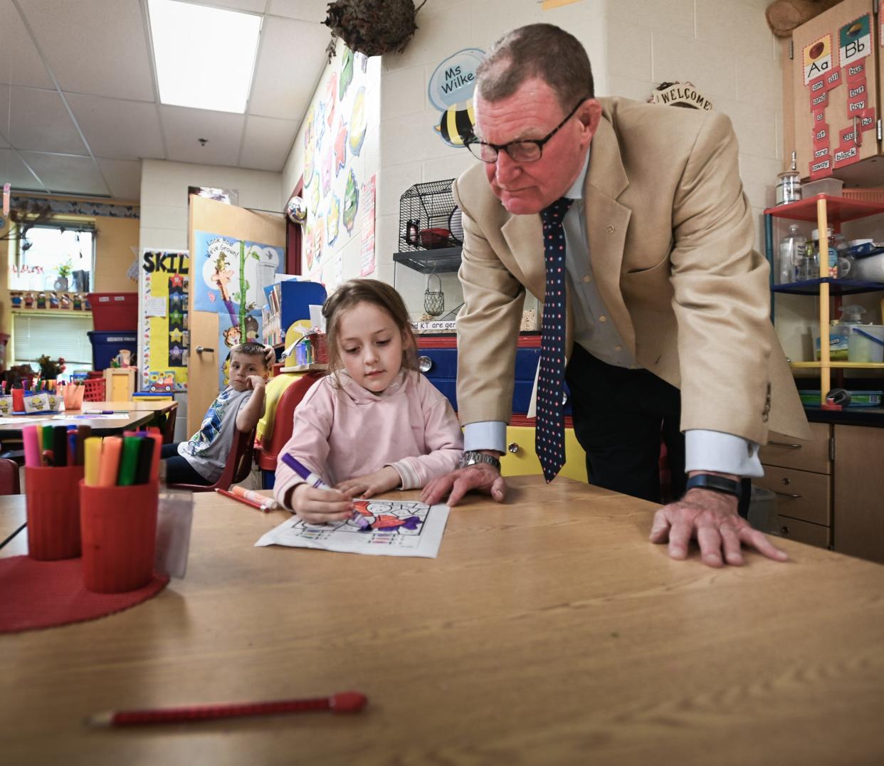 Kindergartner Macie Davis shows Eaton Rapids Public Schools Superintendent Bill DeFrance a project she's working on, Thursday, May 9, 2024, at Greyhound Central Elementary School in Eaton Rapids. DeFrance will retire at the end of the year.